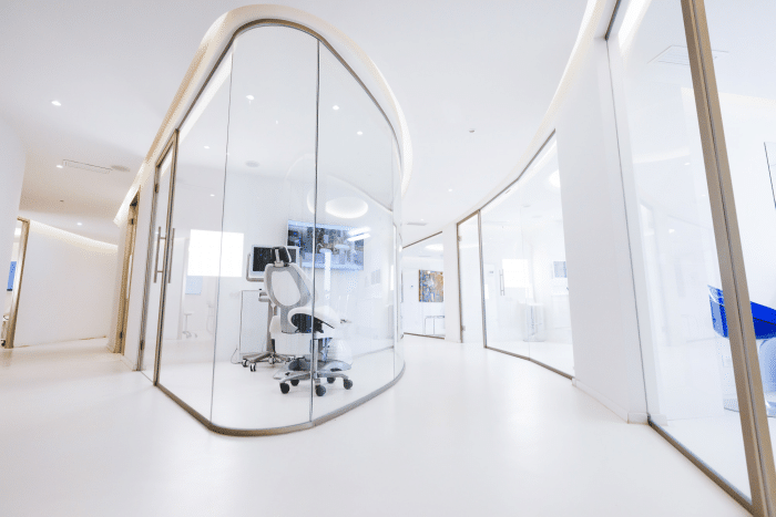 Modern clinic interior with a sleek, white, pod-like treatment room designed for Juvederm lip enhancement procedures, emphasizing a clean and professional atmosphere.