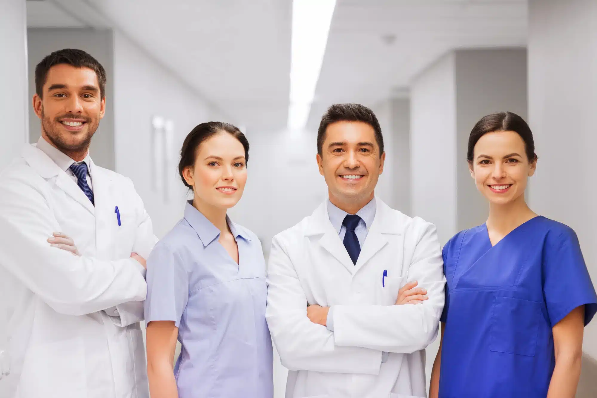 A group of doctors and nurses faced towards the camera, smiling. 