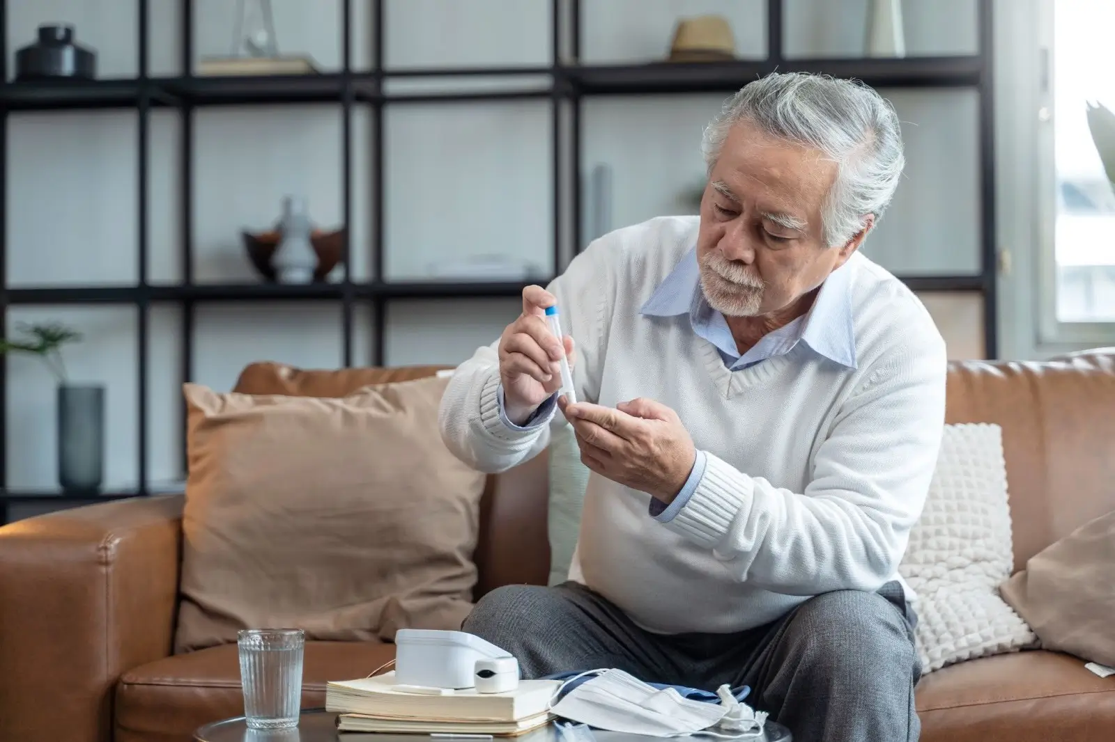 An older man taking Mounjaro checks his blood sugar with a glucose meter.